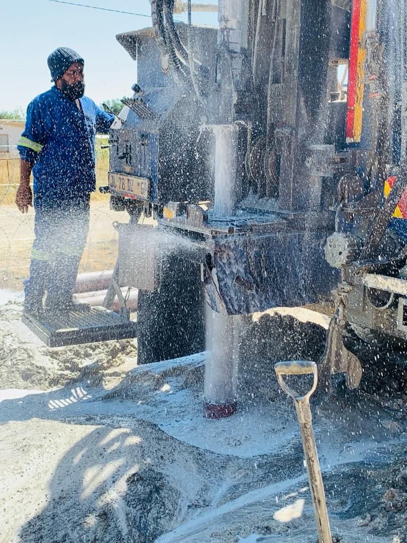 Eco Boreholes technician lowering a submersible pump into a borehole