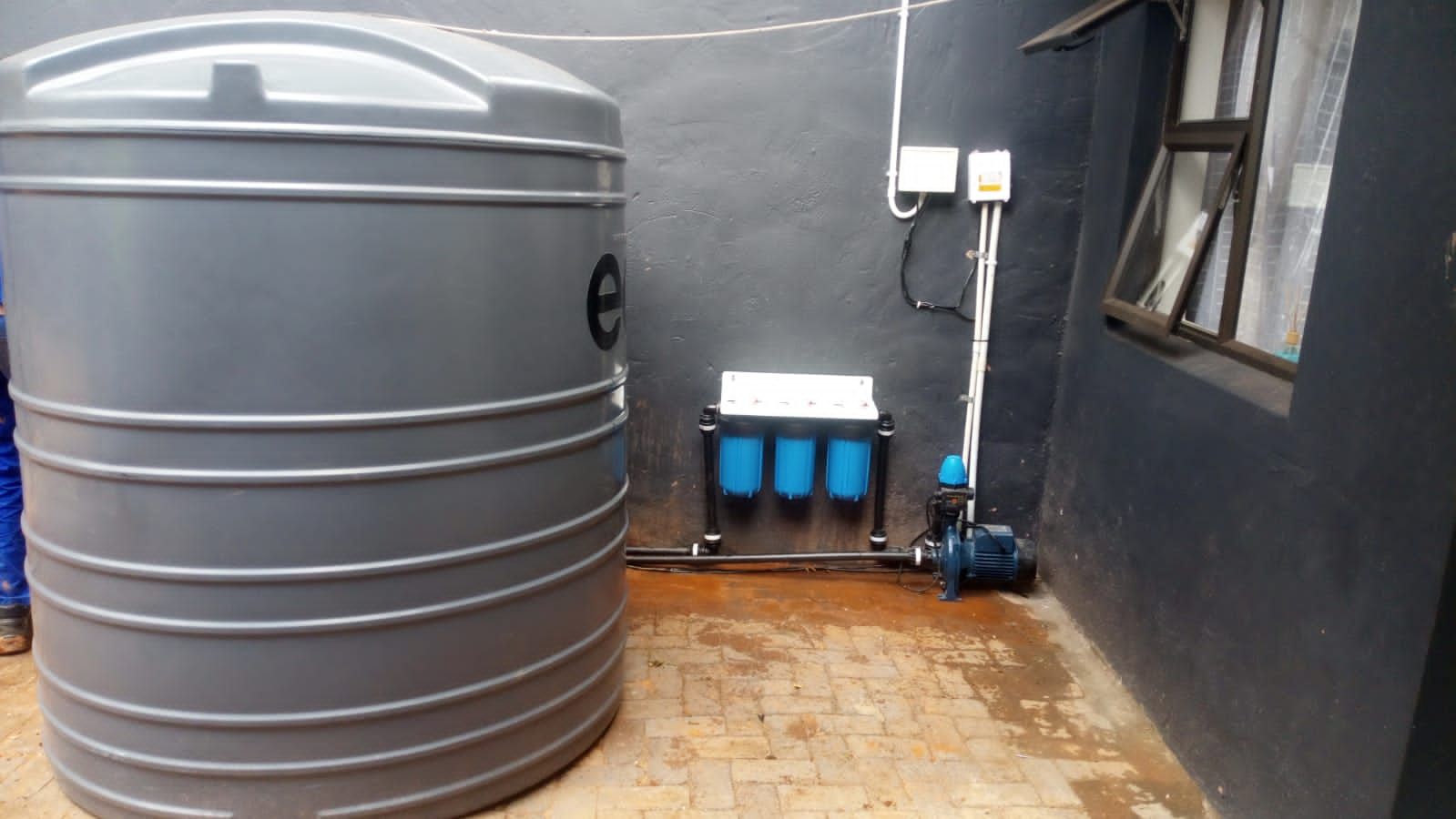 Sediment and carbon water filters installed on an exterior wall