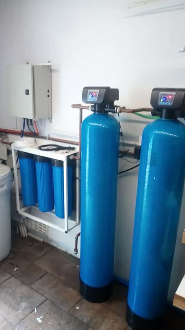 Large green JoJo water storage tanks on concrete base